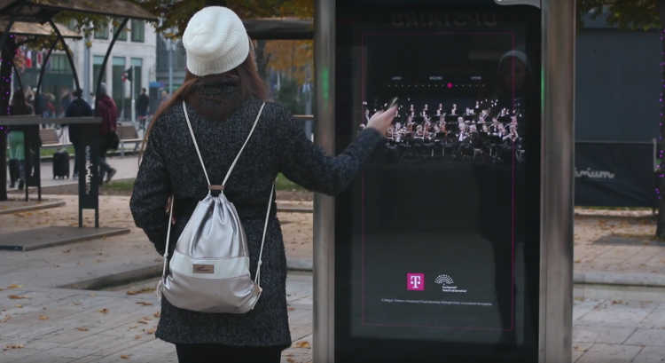 Des passants dirigent l’orchestre du Festival de Budapest sur un panneau publicitaire interactif